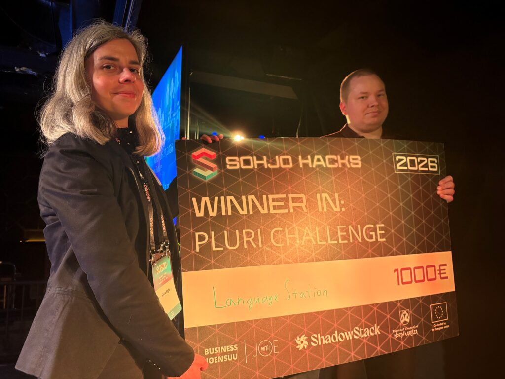 Joonas and Alicja hold a big check at award ceremony